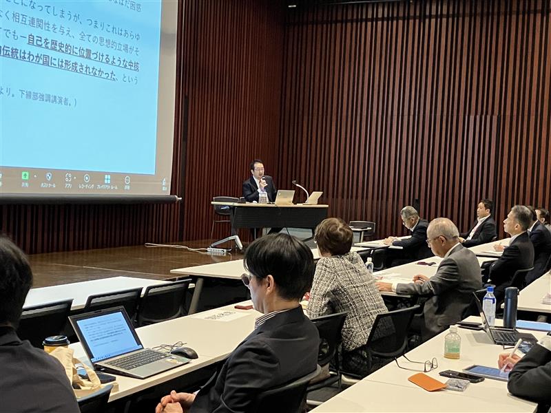 A speaker using a projector to explain