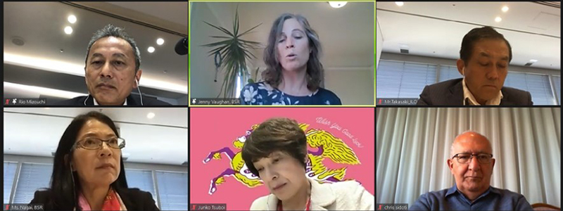 Display screen showing a hybrid meeting with in-person attendees and remote participants