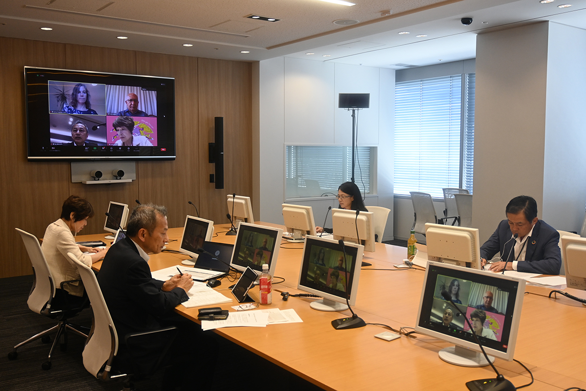 会議室でリアルとオンラインの参加者が一緒にハイブリッドミーティングを行う様子